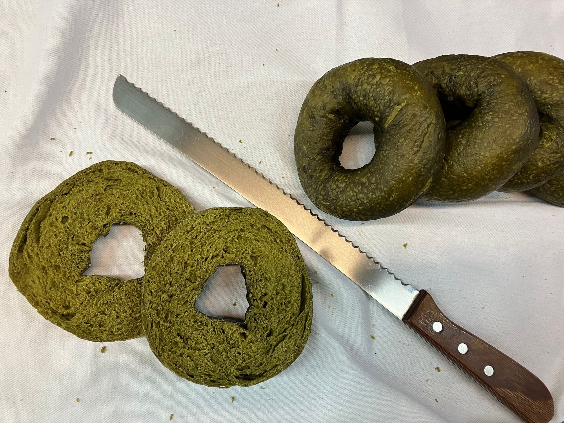 抹茶貝果切面細節，顯示天然抹茶綠與紮實高蛋白麵包體